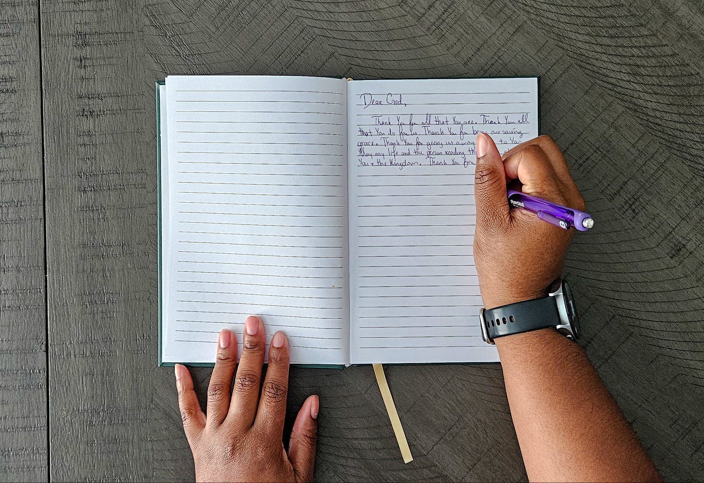 Person writing in a notebook with a pen on a textured surface